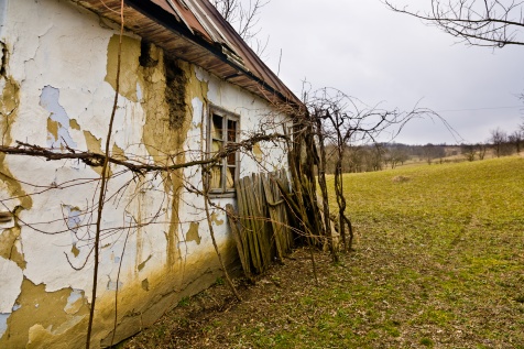 A crumbling old country house sits unused at the bottom of a hill in a little village in Moldova, Romania.