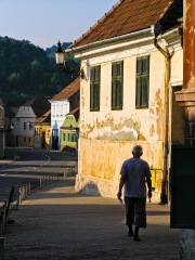 A man walks down a street in the historic city center, Medias, Romania.